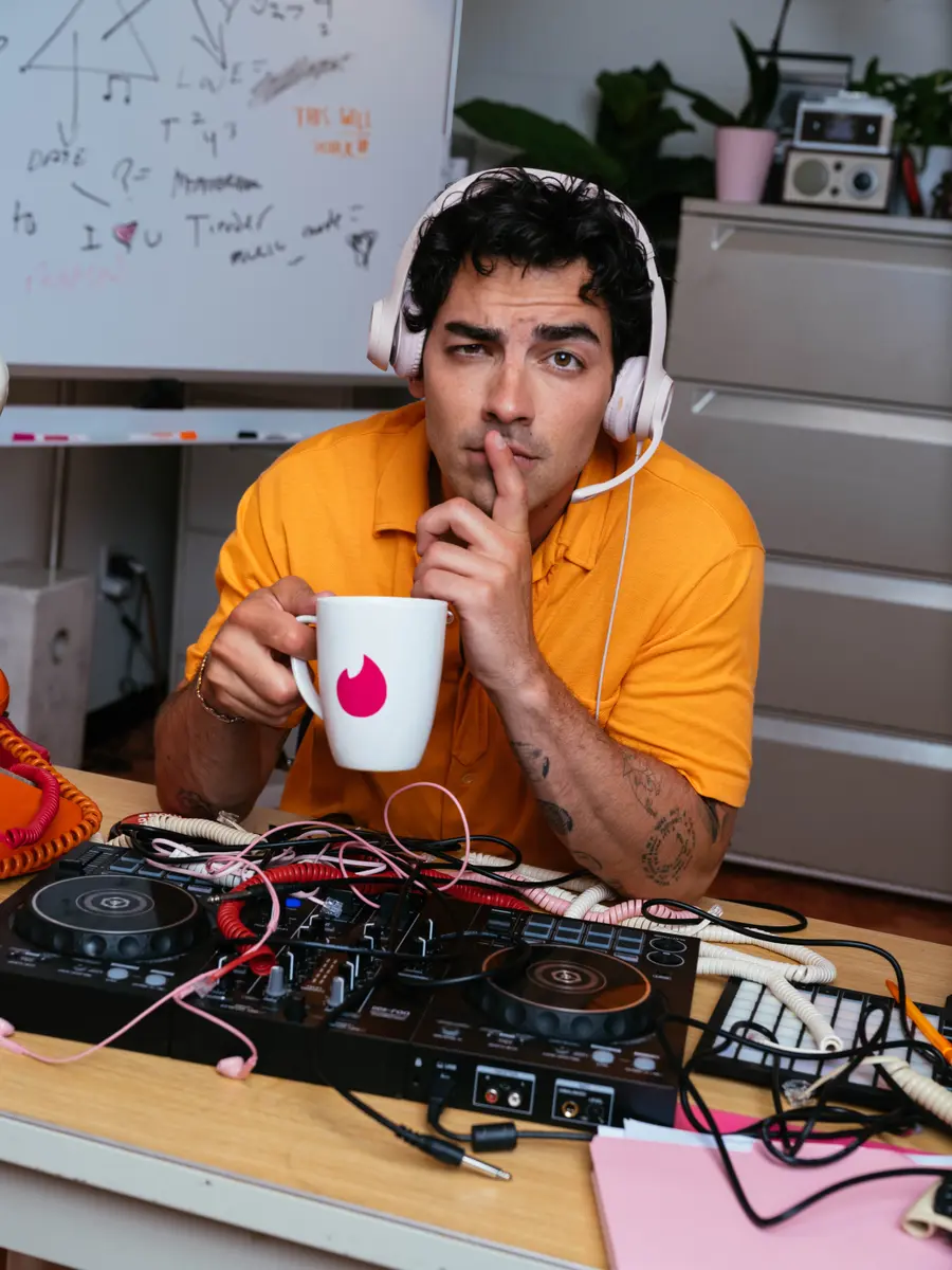 Joe Jonas shushing the camera on the Tinder Music Mode set
